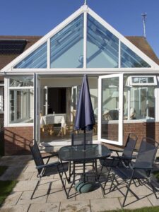 A lean-to conservatory used as a dining area with modern furniture and natural light